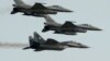 POLAND - Two Polish Air Force Russian made Mig 29's fly above and below two Polish Air Force U.S. made F-16's fighter jets during the Air Show in Radom, Poland, on Aug. 27, 2011
